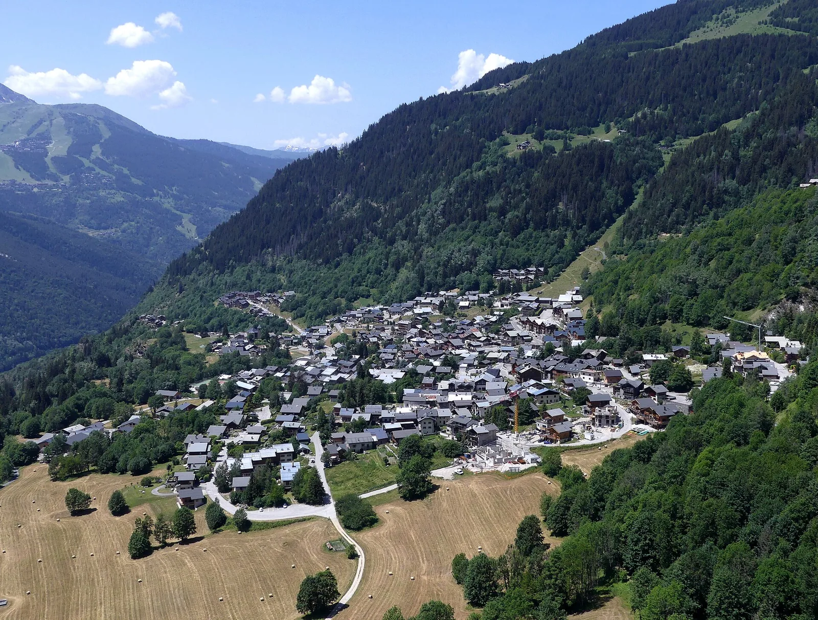Champagny-en-Vanoise village roofs and chalets in early summer with mountains beyond