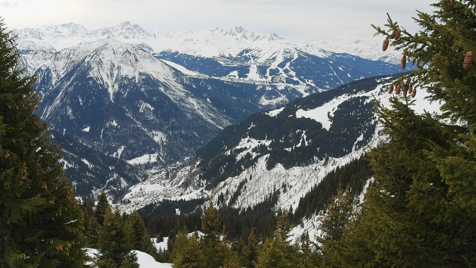 Snowy path toward Champagny-le-Haut with view back to Champagny-en-Vanoise in winter